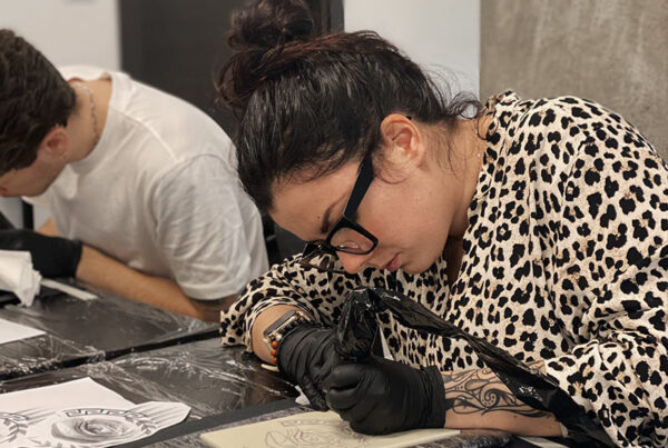 Studentessa tatua su pelle sintetica al corso di abilitazione al tattoo